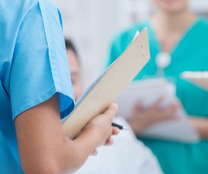 Management | Bildnachweis: getty SDI Productions Pflegeperson hält Klemmbrett